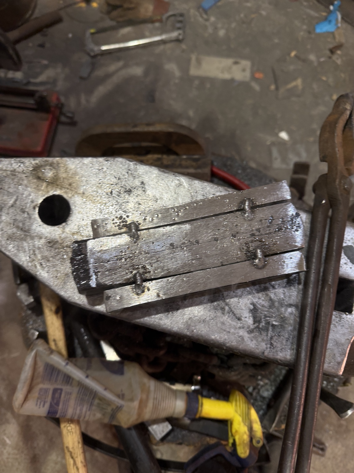 Prepared bars of wrought iron and steel secured together on an anvil before welding