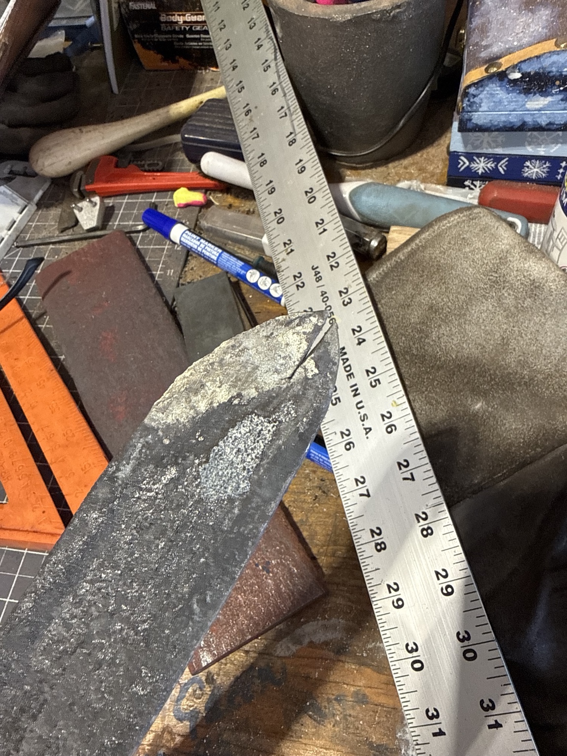 Weld failure visible along the point of the forged blade beside a steel ruler
