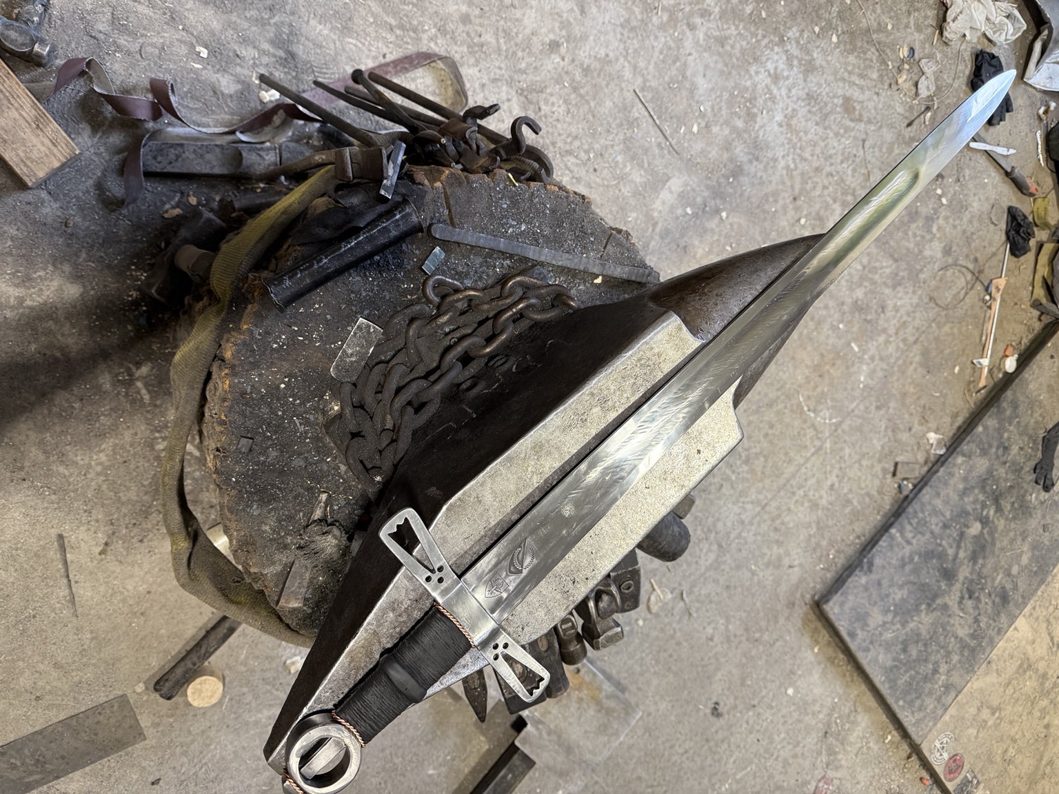 Finished Loch Salann Sword of State resting diagonally on an anvil