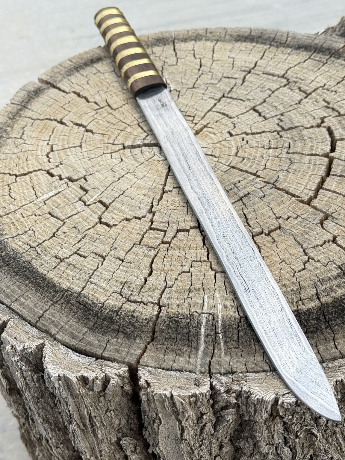 Long knife in profile showing the full length of the blade and handle