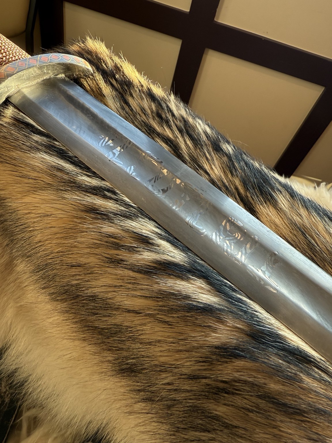 Sword blade with inscription resting on fur during display