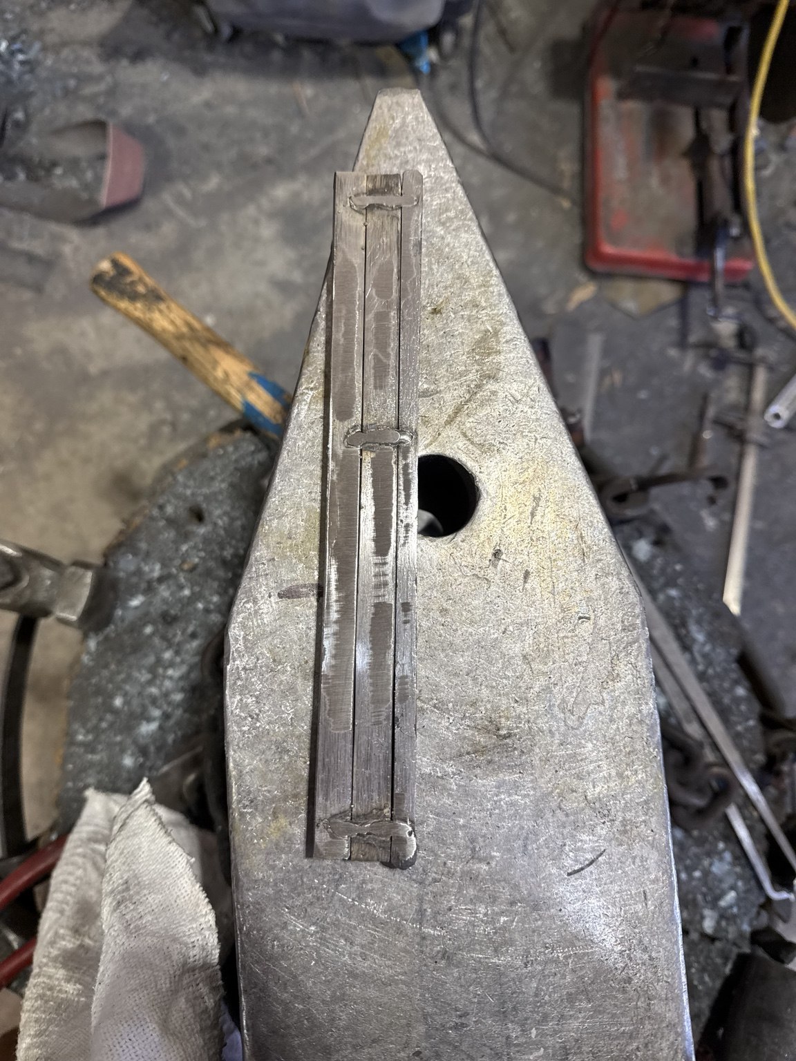 Two twisted bars and wrought-iron component tack-welded in position before forge welding