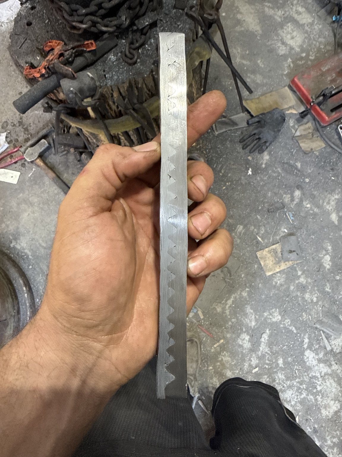 Close-up of etched bar with repeating interlocking wolf-tooth weld line