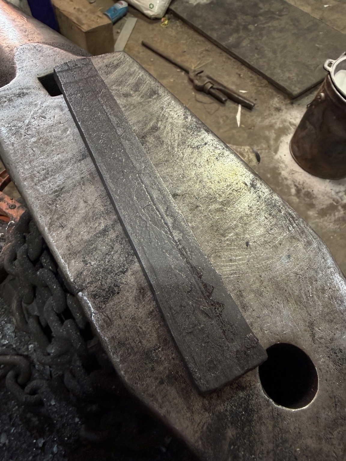 Rough forged composite billet resting on an anvil