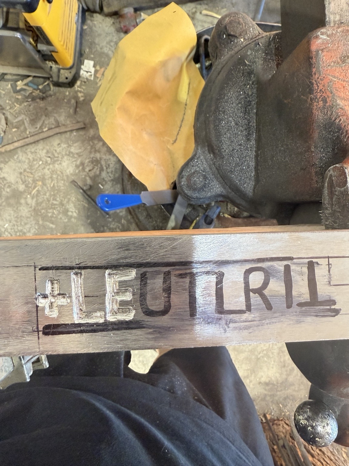 Early stage of the modern River Witham sword inscription, showing already fitted bright metal strokes and marked lines for the remaining letters